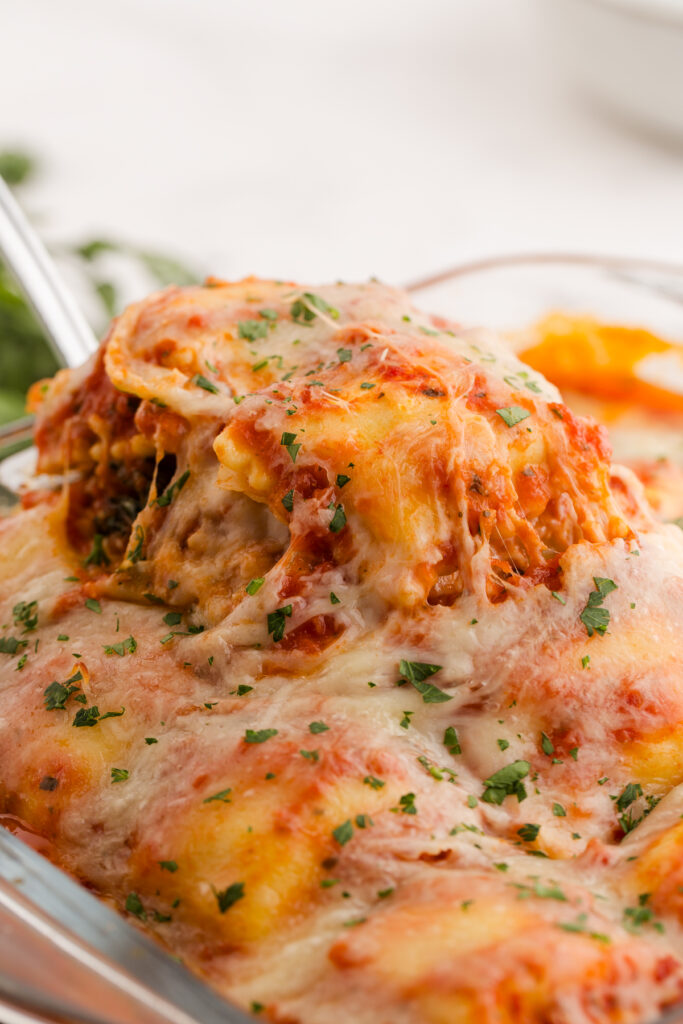 Pasta being pulled out of a dish with a spatula