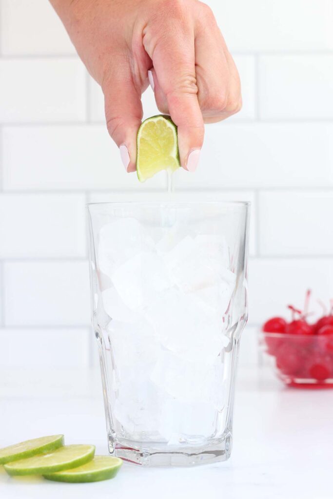 glass filled with ice having a lime squeezed into it