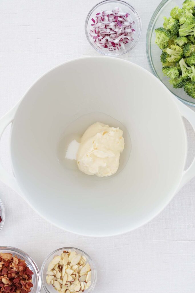 top down image showing a white mixing bowl with mayonnaise, sugar, vinegar