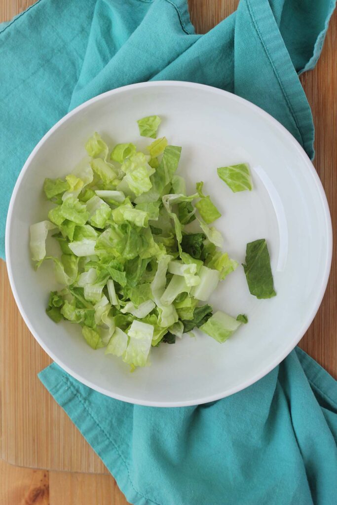 top down image showing lettuce in a white bowl