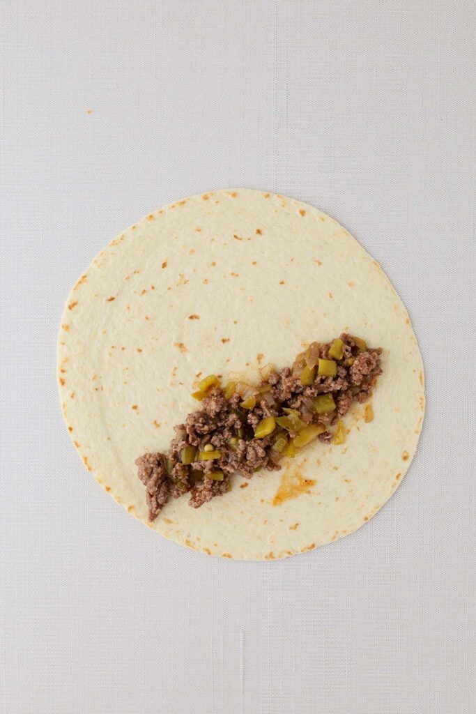 Top down image showing a tortilla with beef on top