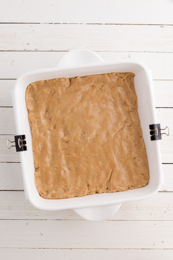 Top down image showing an unbaked blondie batter inside a 9 inch pan