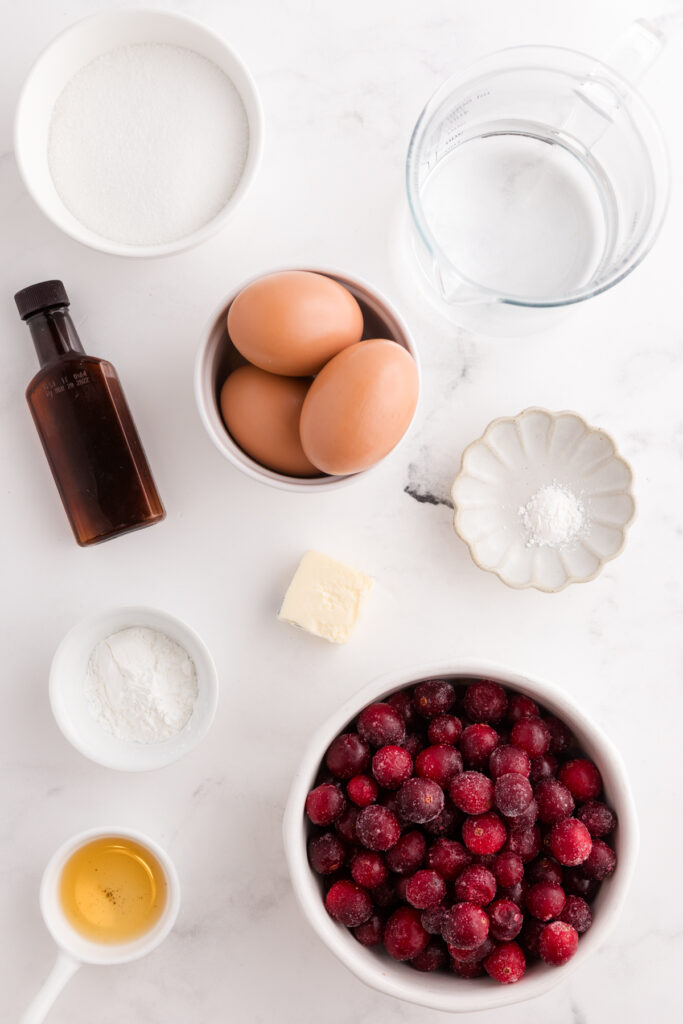 Top down images showing everything you need to make a cranberry pie laid out on a white countertop