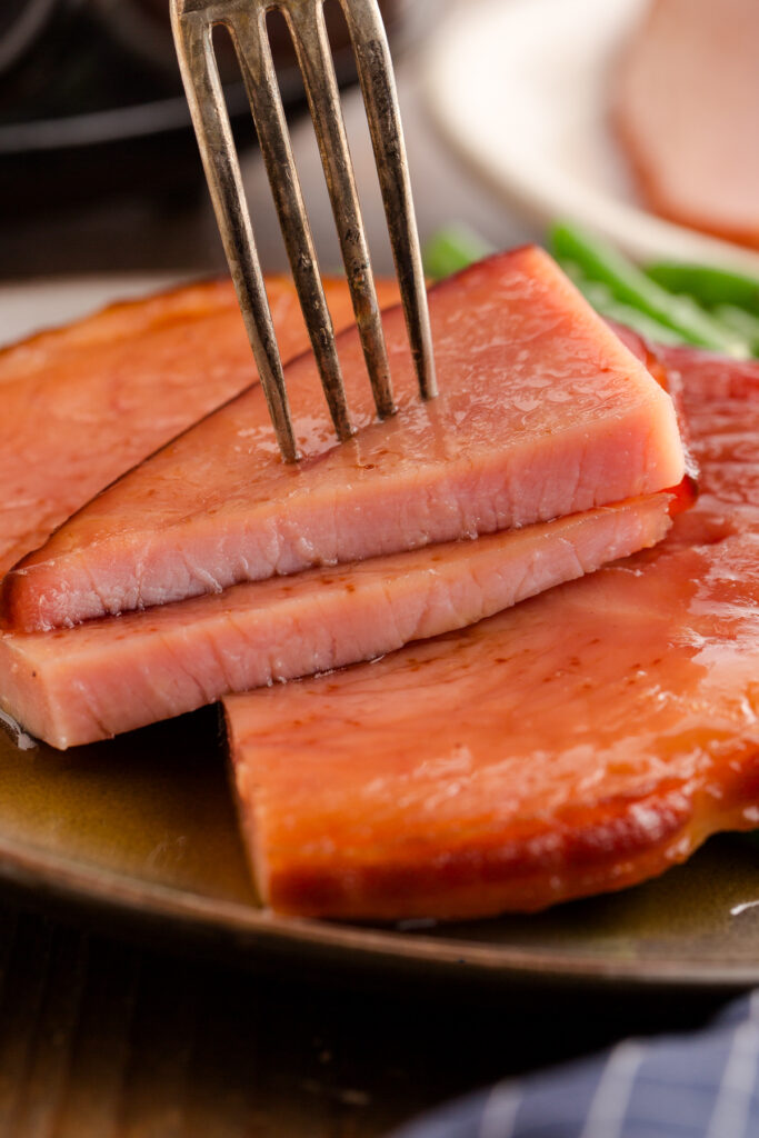 a fork picking up a piece of cut ham