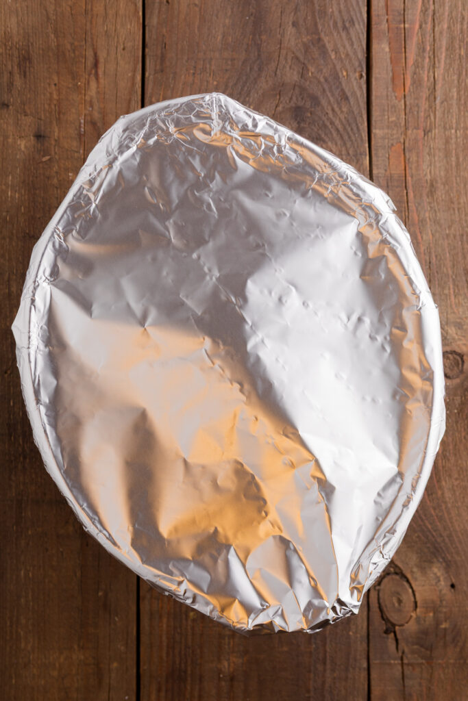 top down image showing a slow cooker covered in foil