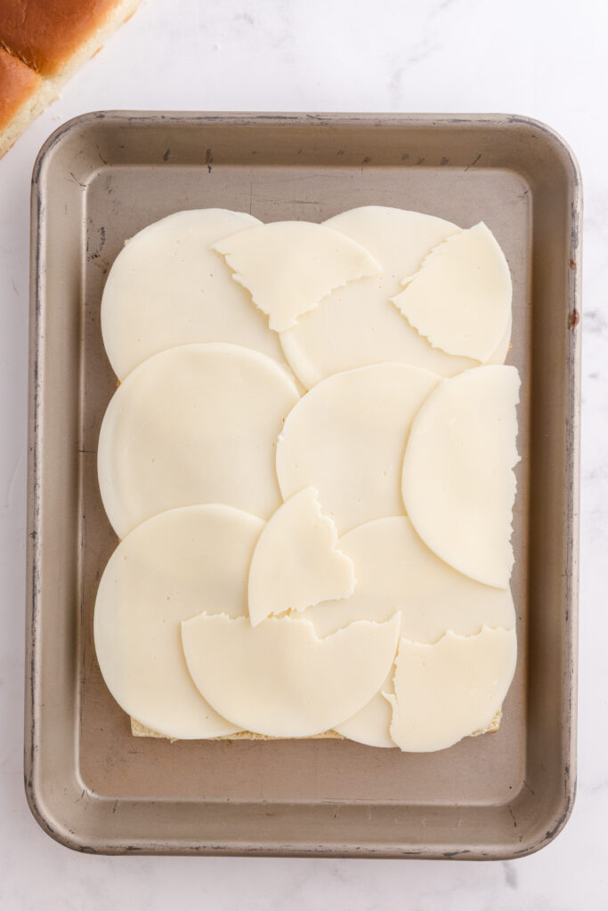 Top down image showing rolls sliced in half with cheese on top