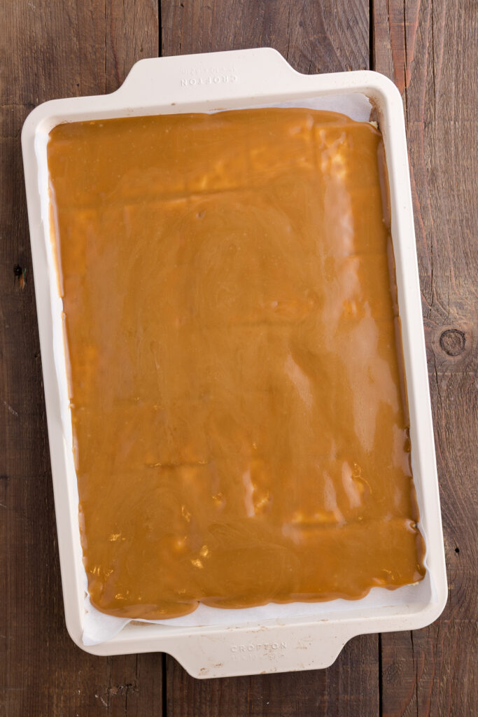 Baking sheet lined with saltine crackers arranged in a single even layer topped with toffee