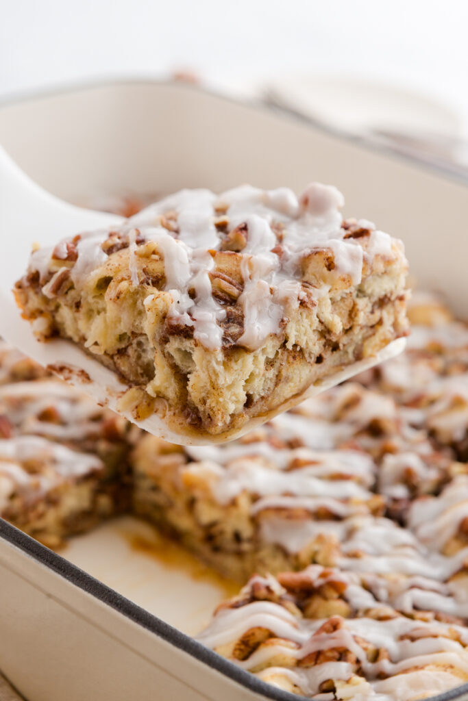 spatula pulling out a slice of sweet roll bake form a 9x13 pan