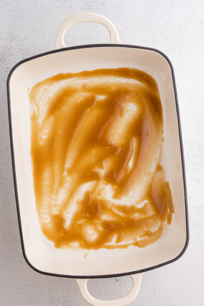 Top down image showing a 9x13 pan with a brown sugar mixture in the bottom