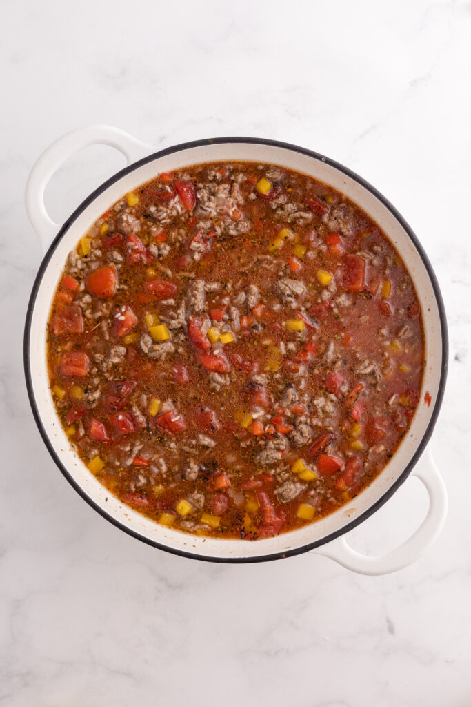 Beef and rice mixture cooking together until the rice begins to soften and absorb the sauce.