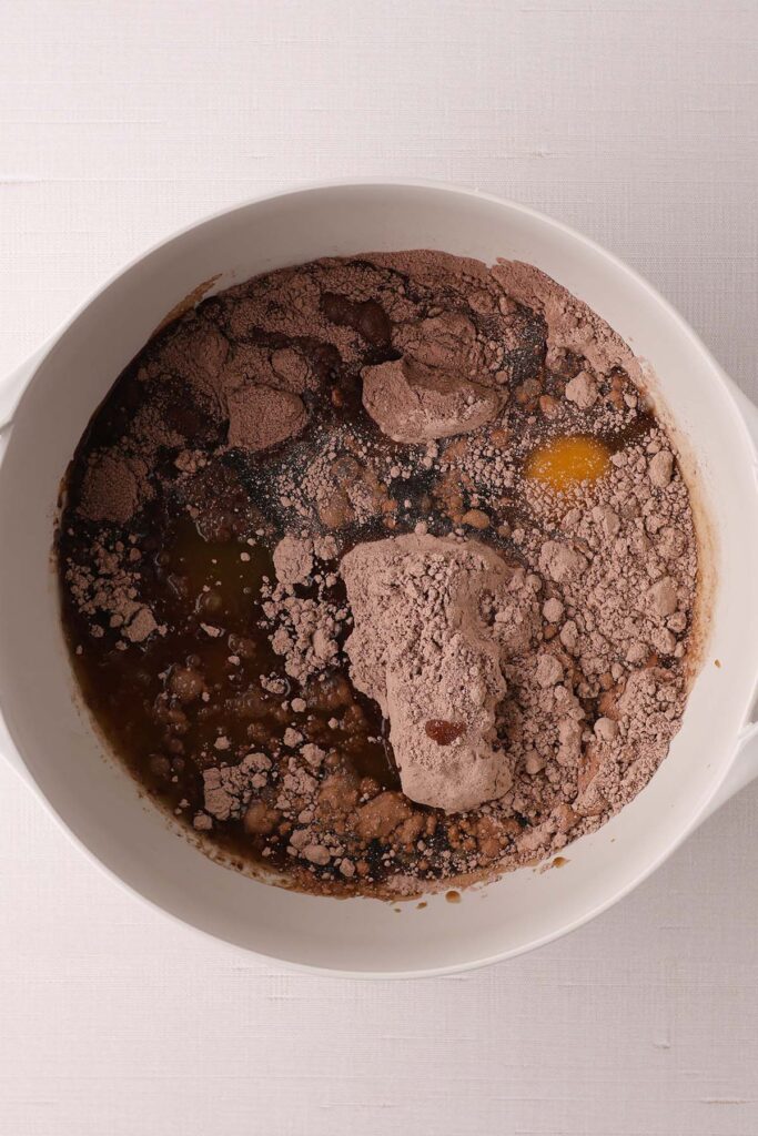 Top down image showing a cake mix inside a mixing bowl with all of the ingredients unmixed