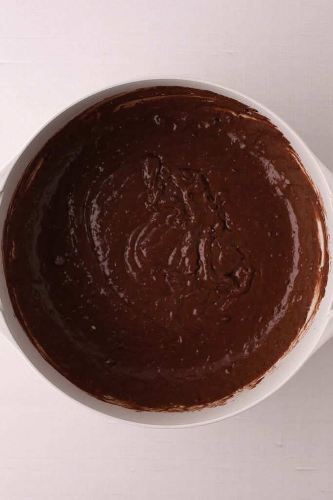 Top down image showing a cake mix inside a mixing bowl with all of the ingredients mixed