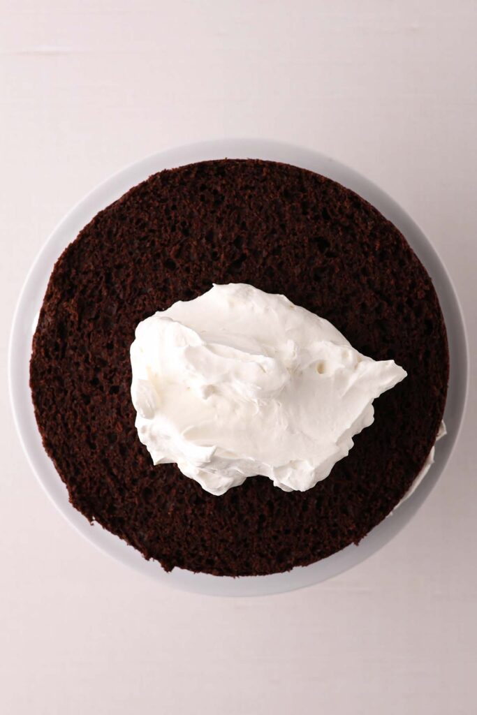 top down image showing a chocolate cake layer with a dollop of whipped cream on top