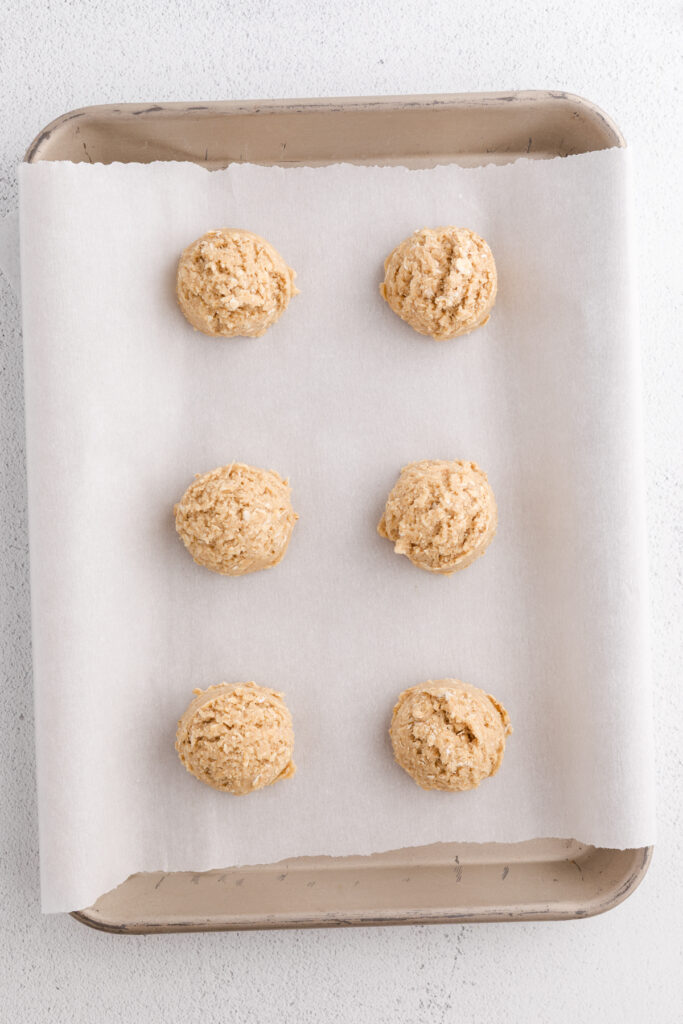 top down image showing cookie dough balls on a parchment lined tray
