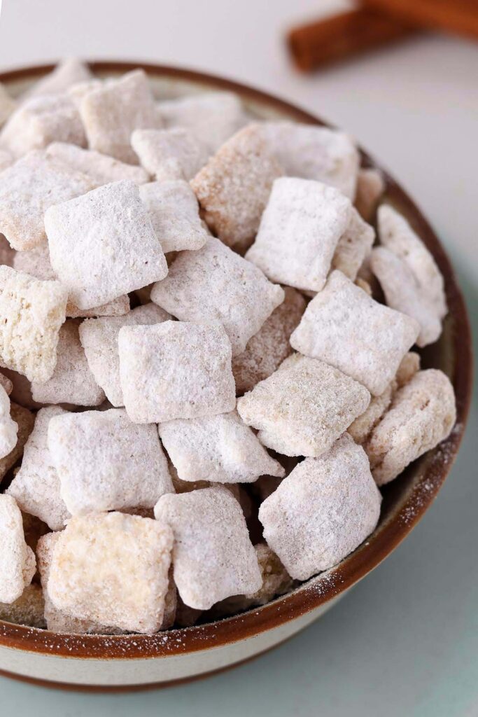 close up image showing cereal coated in powdered sugar in a brown bowl
