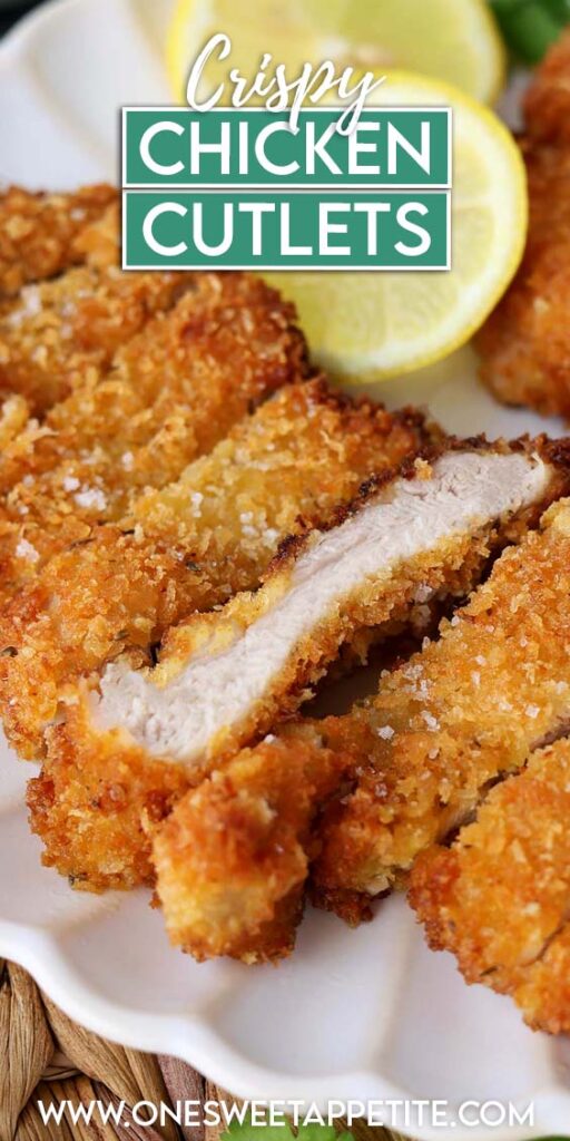 Close up image showing two golden brown chicken cutlets sliced on a white plate with lemon slices. Text overlay reads "crispy chicken cutlets"