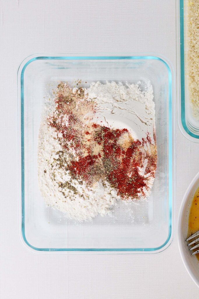 Top down image showing a rectangle glass dish with flour and seasonings