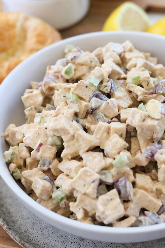 close up image showing chicken salad in a white bowl