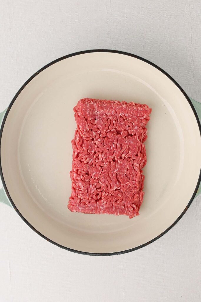 Top down image showing uncooked ground beef in a pan