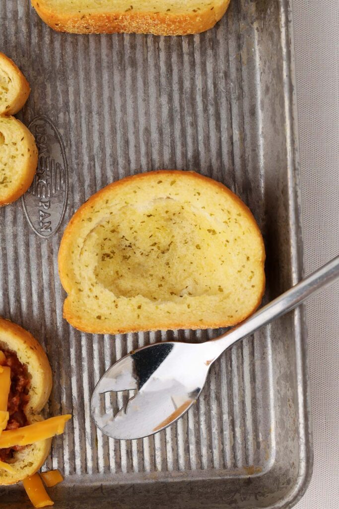 Top down image showing a baked garlic toast with the center pressed down