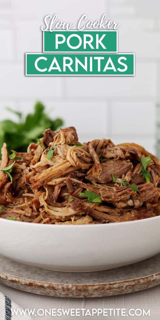 Bowl of shredded pork carnitas topped with chopped cilantro, showing tender strands of slow-cooked pork in cooking juices.