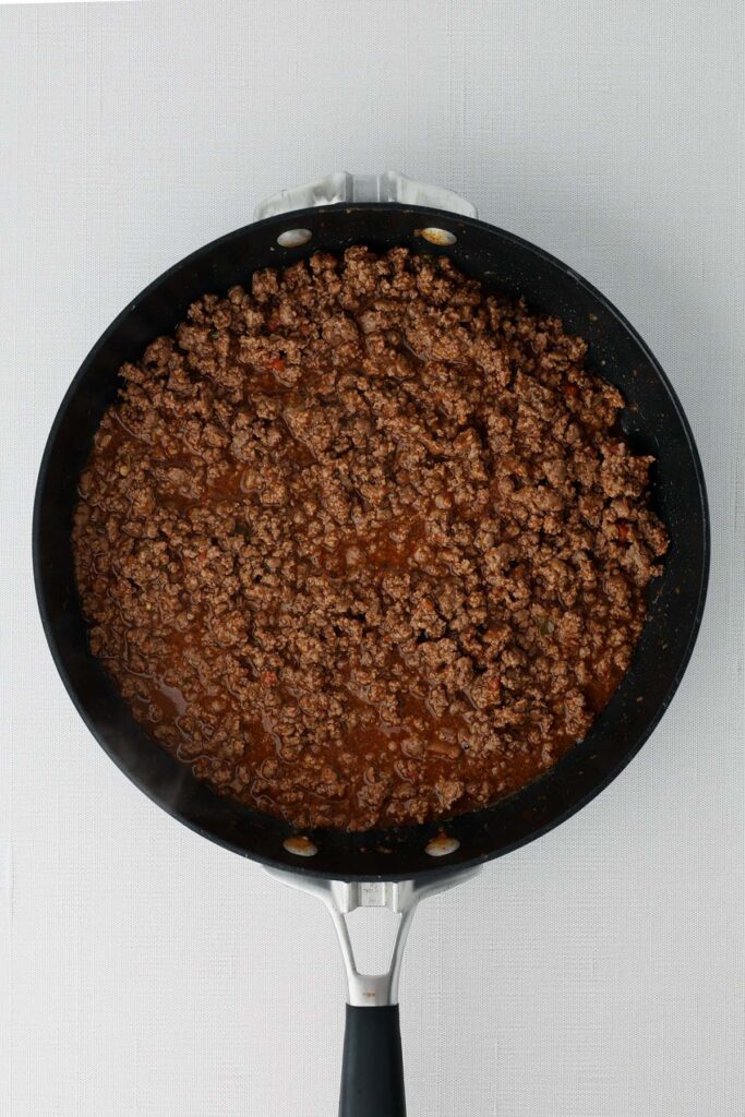 top down image showing a black skillet with saucy beef