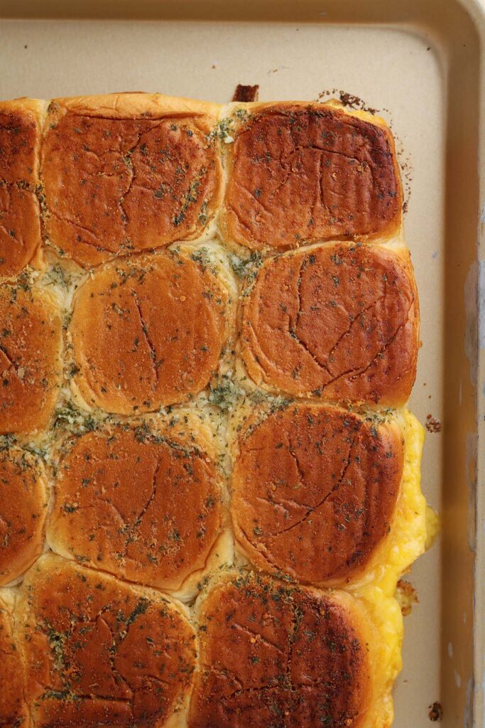 Top down image showing smashed down sliders with garlic butter and cheese coming out the sides