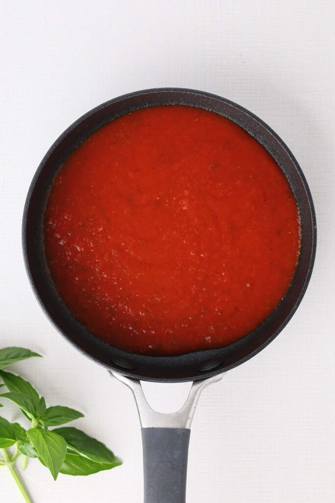 Top down image showing a small black skillet filled with sauce