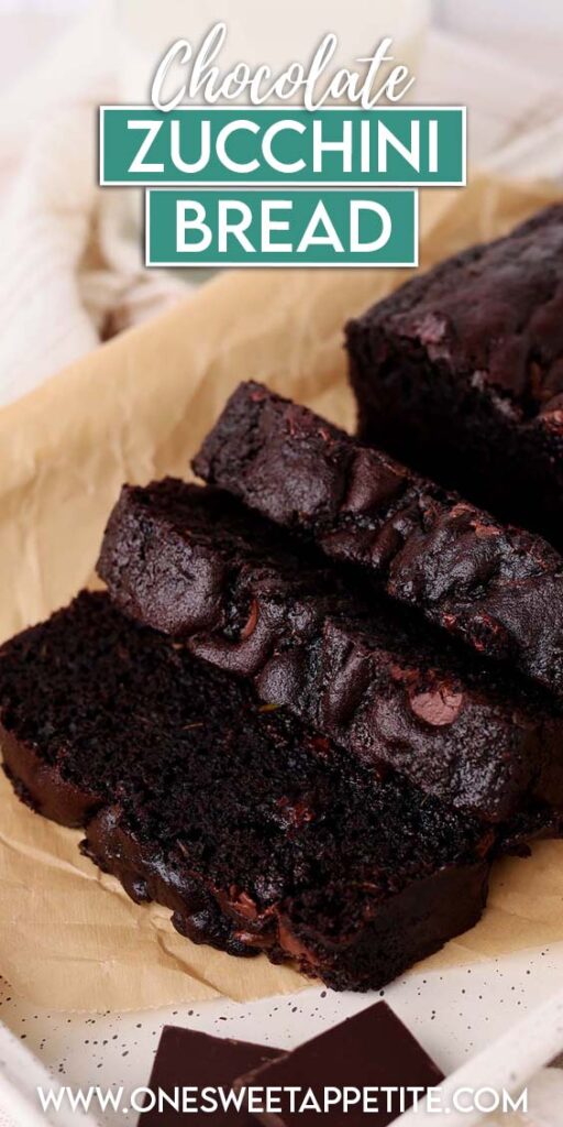 Close up image showing three sliced of chocolate zucchini bread sitting on a brown parchment paper on a white tray with pieces of chocolate next to it. TExt overlay reads "chocolate zucchini bread"